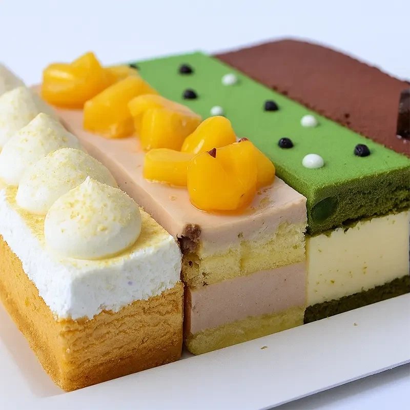 Assorted layered cakes made with premium cake premix, featuring whipped cream, fruit toppings, and matcha flavors for soft texture and mineral-free baking