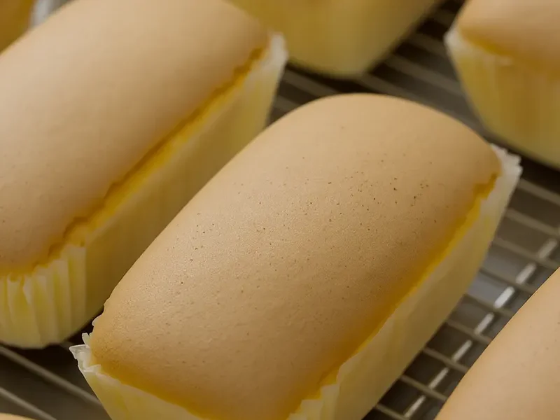 Fluffy golden sponge cakes with smooth tops, showcasing improved baking powder formulation for better texture and reduced ingredient costs