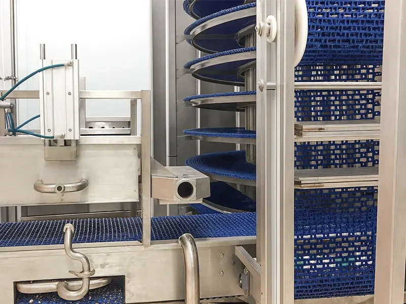 Automated spiral cooling conveyor system in commercial bakery—enhances custard-filled product stability and supports efficient large-scale pastry production
